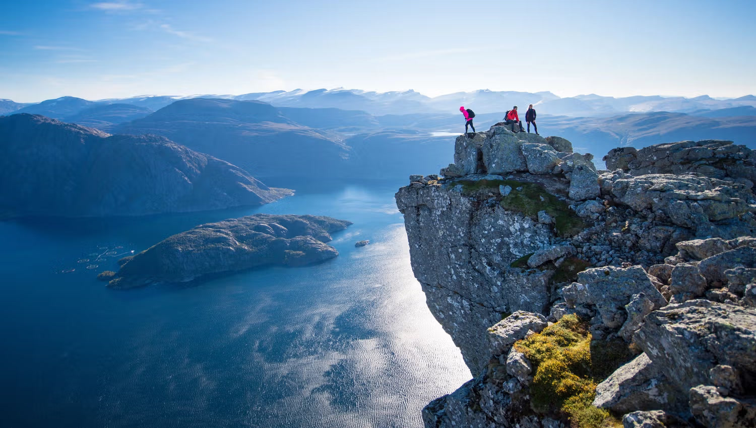 A person on the edge of Hornelen, Europe's highest sea cliff, above the fjord