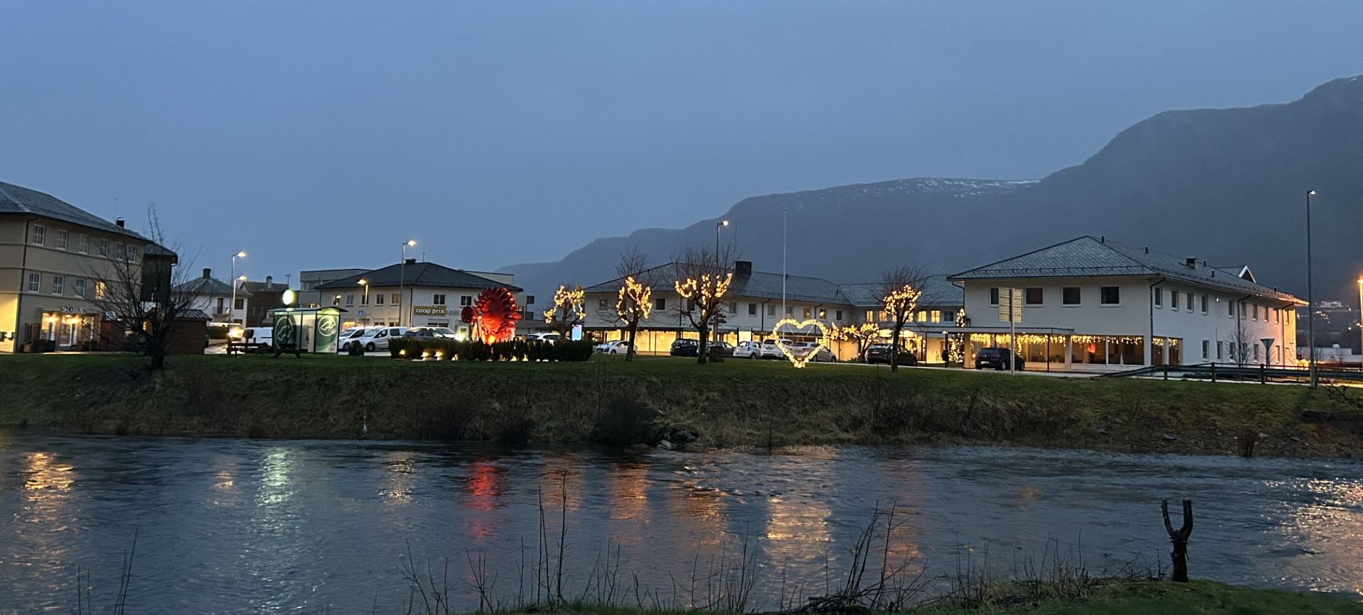 Svelgen lit up on a winter evening, the fjord dark beyond the houses