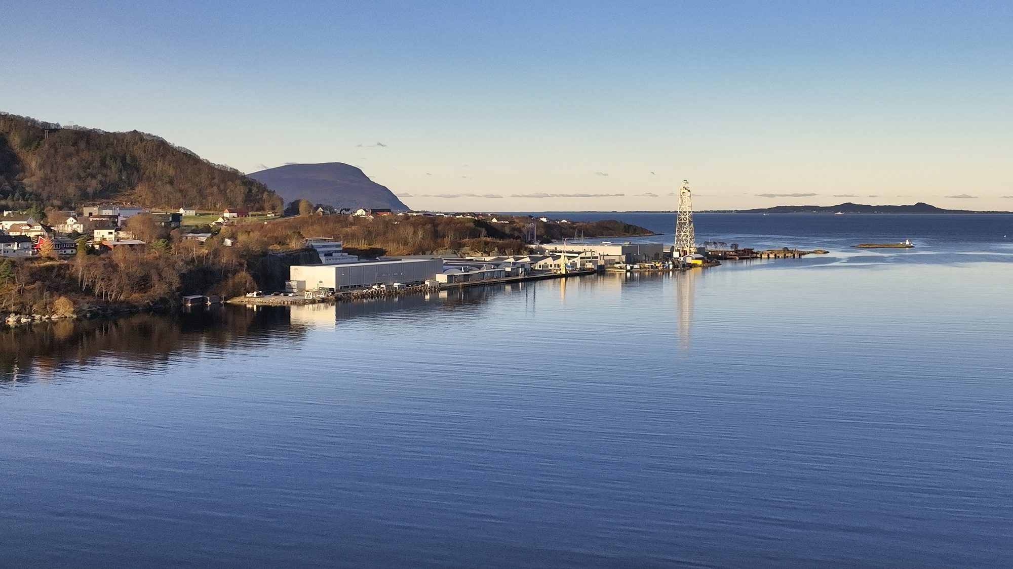 The Kongsberg Maritime factory on the fjord at Brattvåg, with the test tower and the Sunnmøre mountains behind