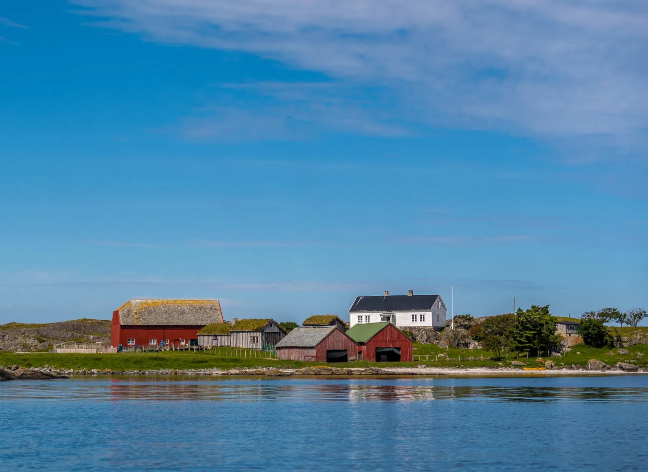 Traditional red farm buildings by the shore at Harøya