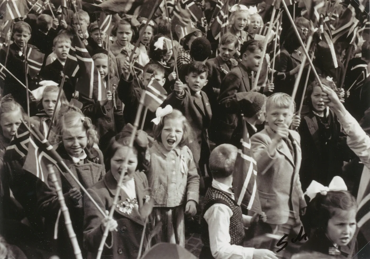 Happy children waving Norwegian flags during the 17th of May parade in Trondheim, 1945