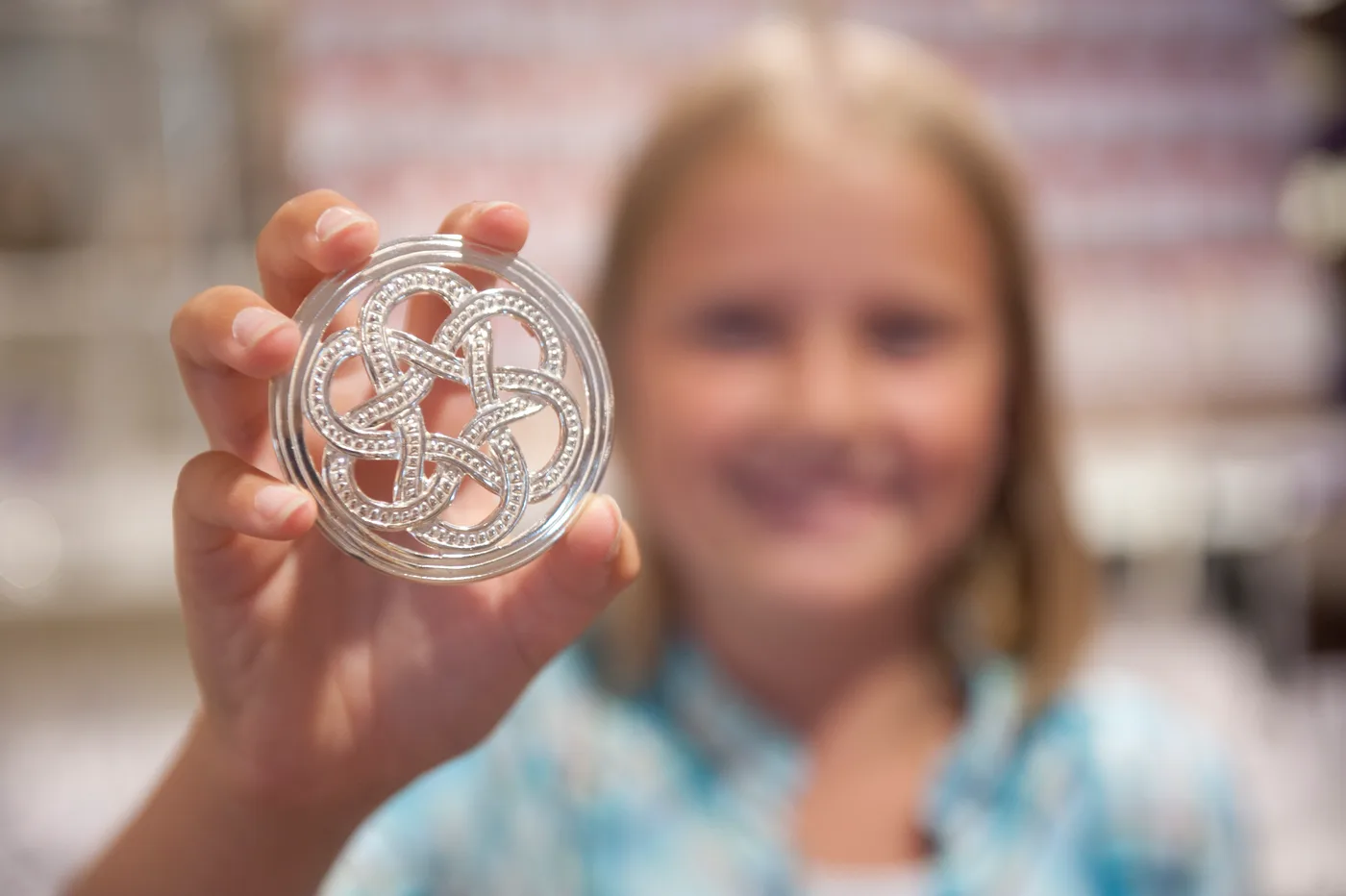 A young silversmith carefully working on a filigree piece at a brightly lit workbench, carrying forward the Setesdal tradition