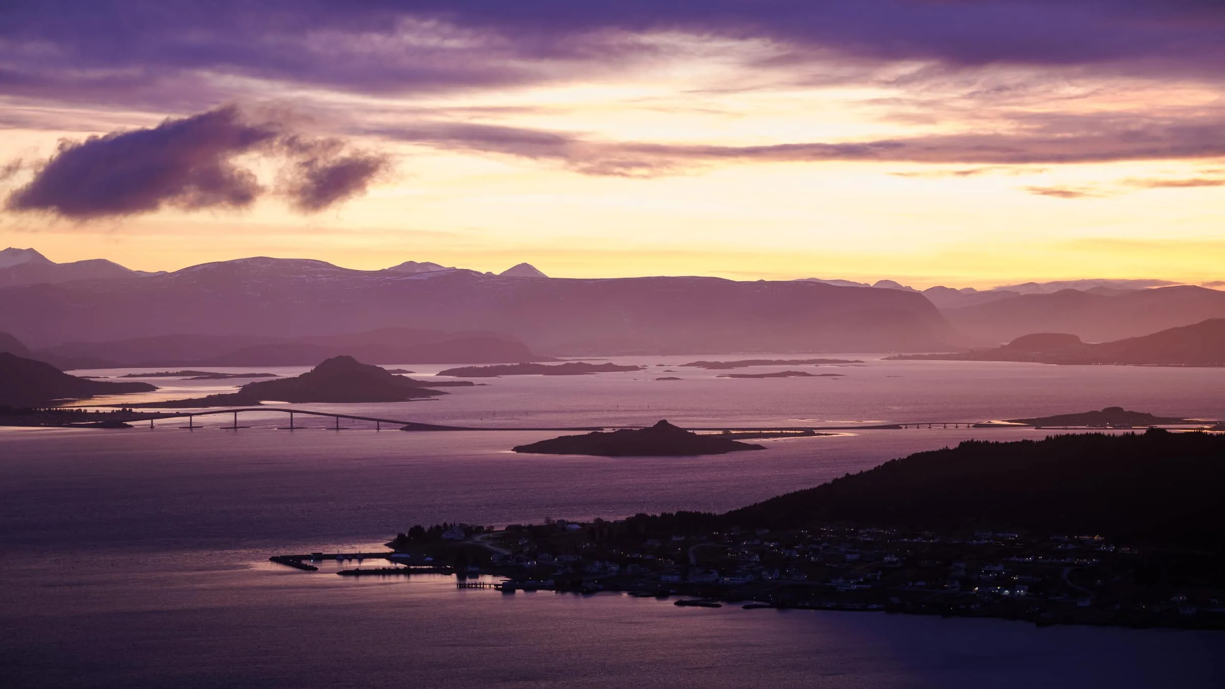 Panoramic view of the Nordøyane islands with bridges, sea and mountains in purple evening light