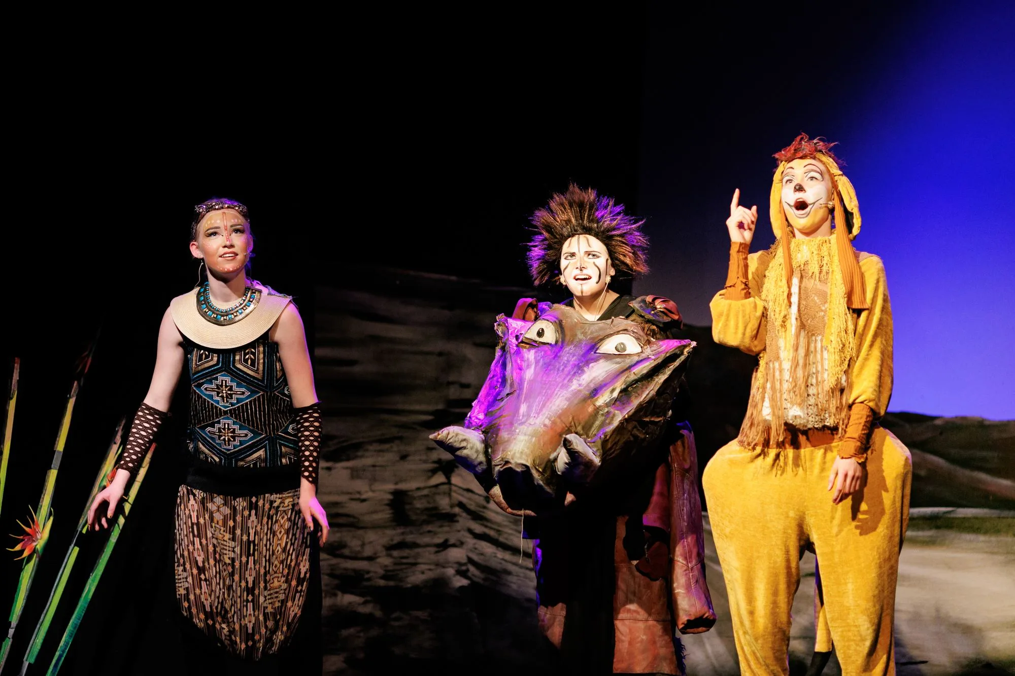 A scene from The Lion King performed by the Nordøyane theater group with colorful costumes and stage design