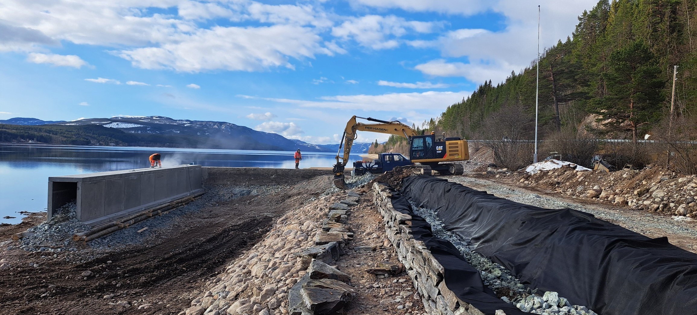 Per Hagen AS at work — excavator on a lakeside infrastructure site