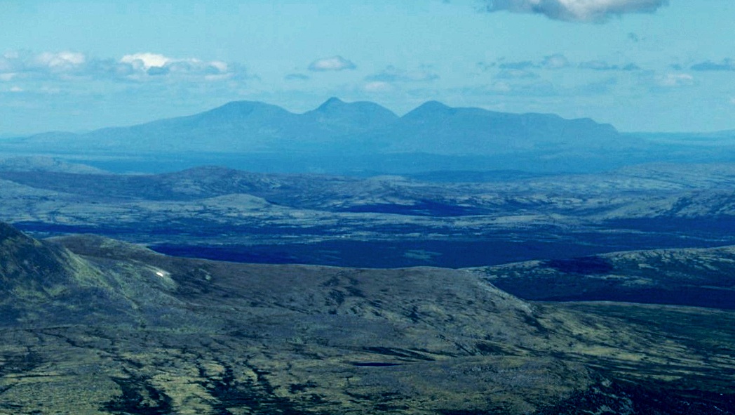Sølenfjellet in the distance — blue ridges against a hazy sky, low mountain plateau in the foreground