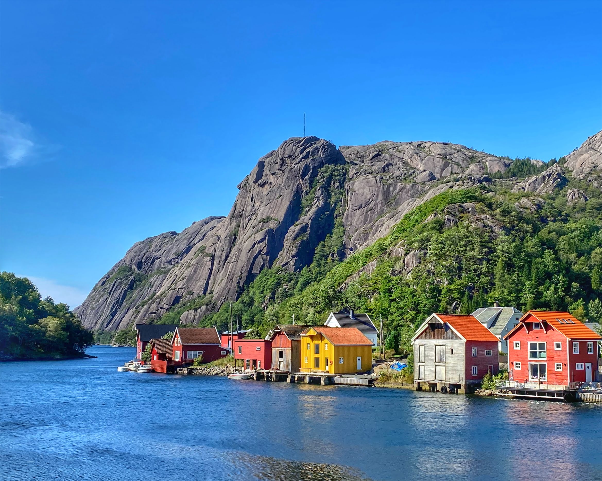Aerial view of Åna-Sira village where the Sira river meets the fjord, surrounded by green hills