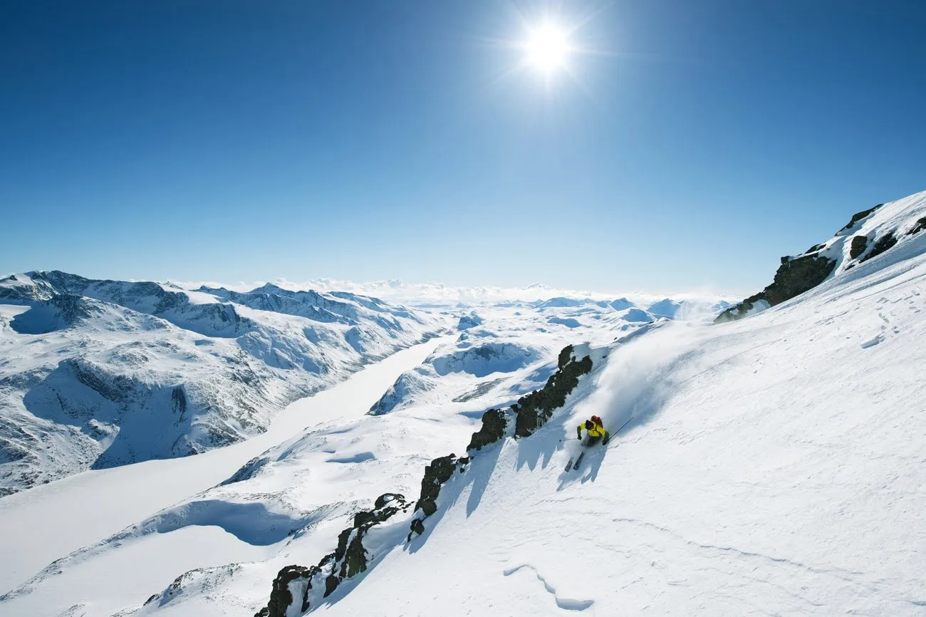 Person skiing in snowy landscape and bright sun