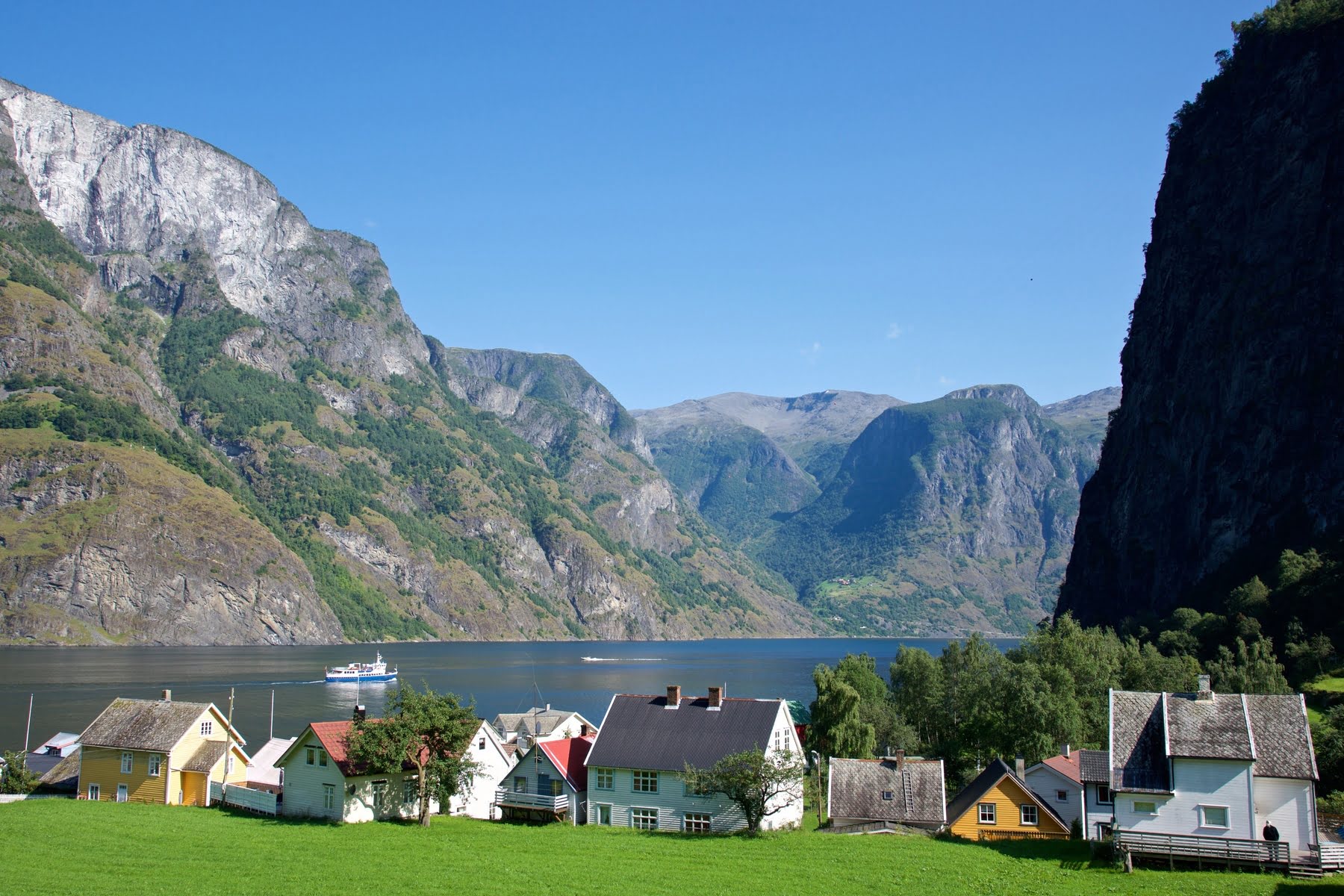 Undredal village tucked between steep mountains along the Sognefjorden with colourful wooden houses